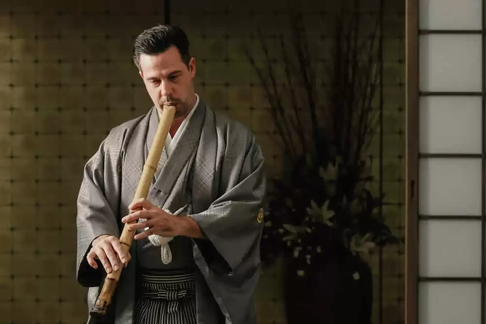 Photograph of Shawnee Schroeder playing the Shakuhachi